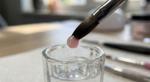 Close up macro shot of a brush picking up a perfect pink powder bead