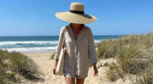Woman wearing a wide-brimmed straw hat on the beach for sun protection.
