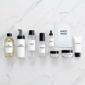 A complete Korean skincare routine set including oil cleanser, toner, and serum arranged on a white marble background.
