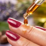 Applying hydrating oil to cuticles for essential acrylic nail care and natural nail health.