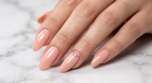 Acrylic nail care guide showing healthy natural nails underneath elegant nude enhancements.